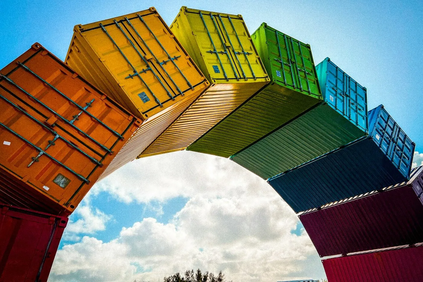 The Rainbow Sea Container Arch sculpture by Marcus Canning in Pioneer Park, Fremantle — stacked shipping containers in rainbow colours framing a blue sky