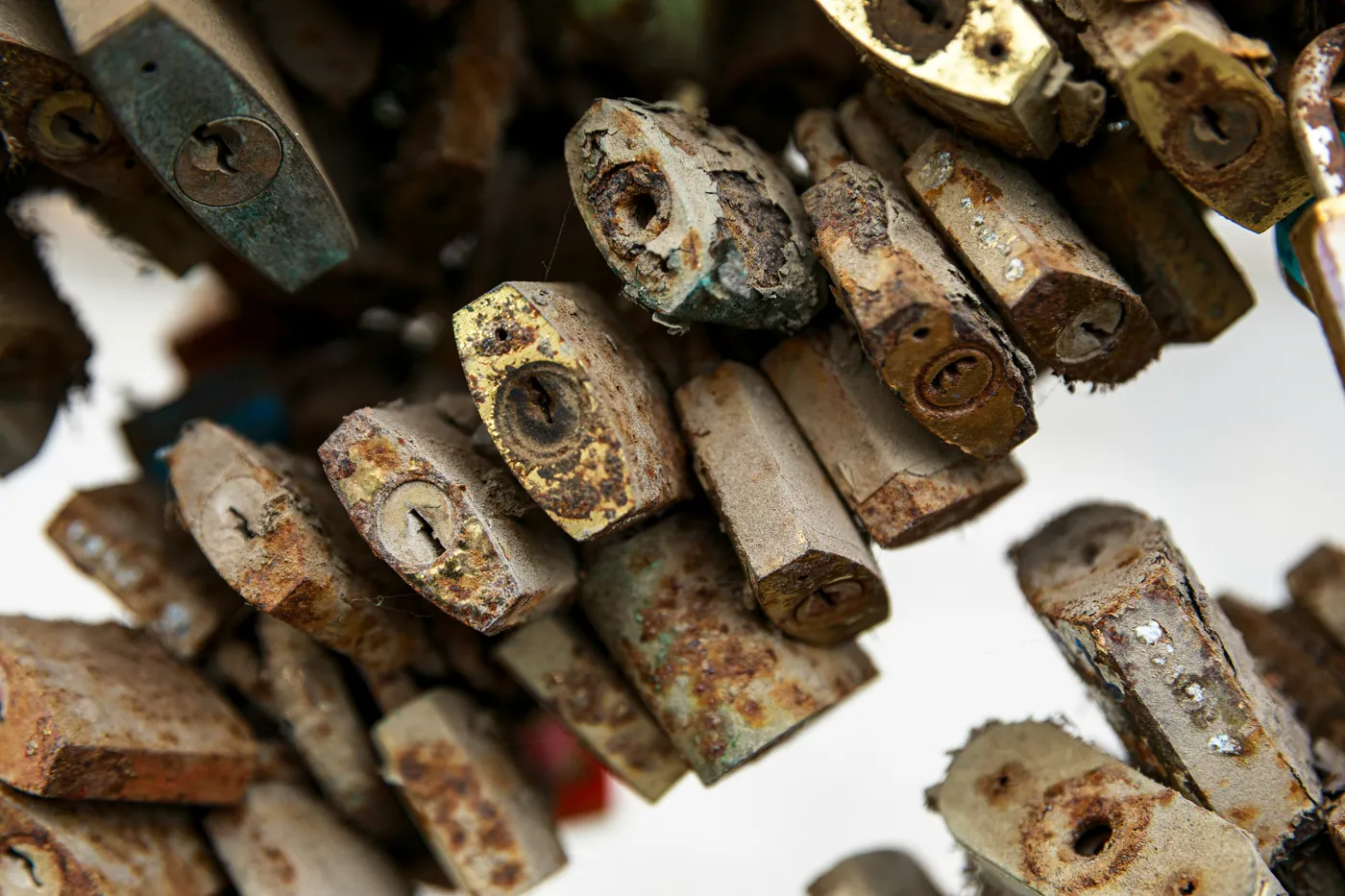 Close-up of dozens of old, rusted padlocks hanging together