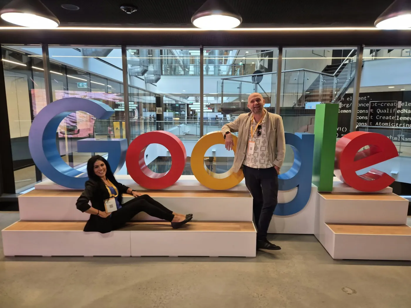 Petr Červenka and Erin Bell beside the coloured Google letters in the atrium of Google's Sydney office