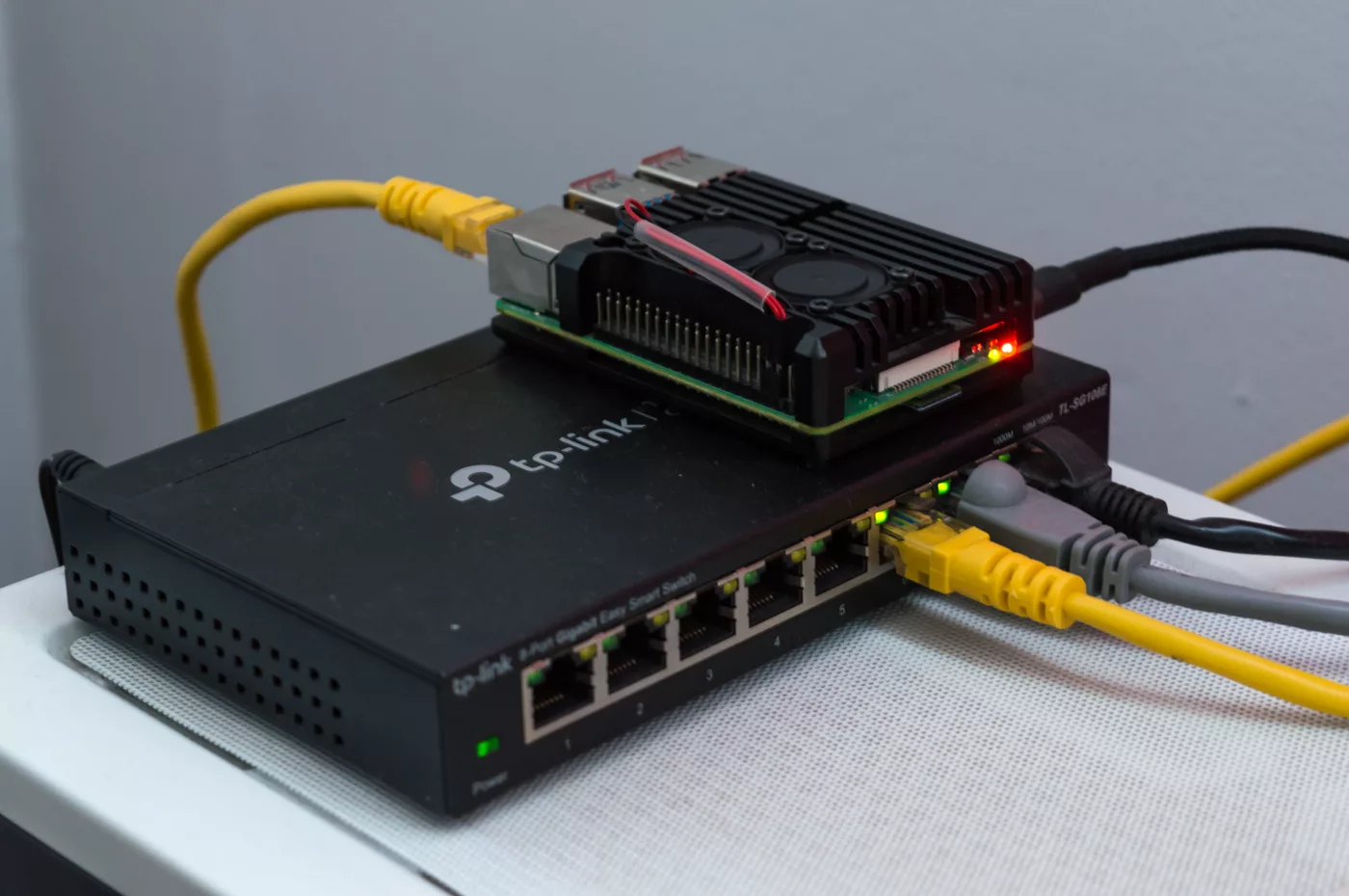 A Raspberry Pi 4 board sitting on top of a network switch
