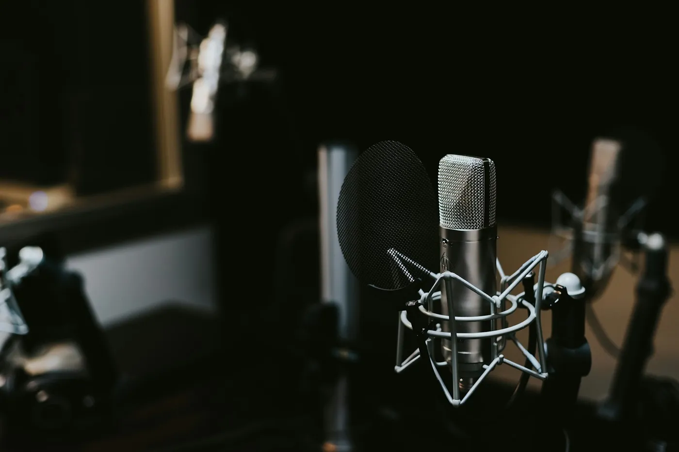 Studio condenser microphone with a pop filter in a dark room