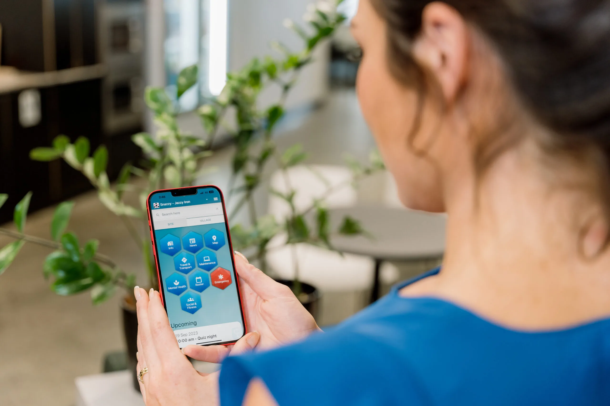 A worker holding a phone showing the Co-Connect App home screen